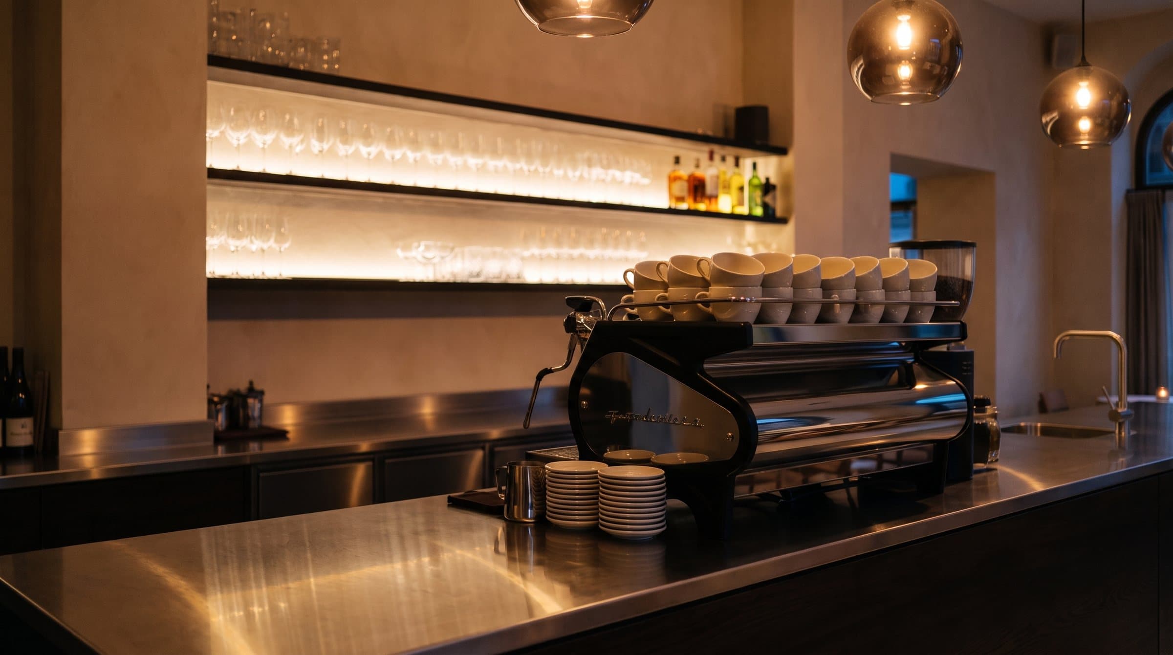 Chrome espresso machine and stacked cups at the bar
